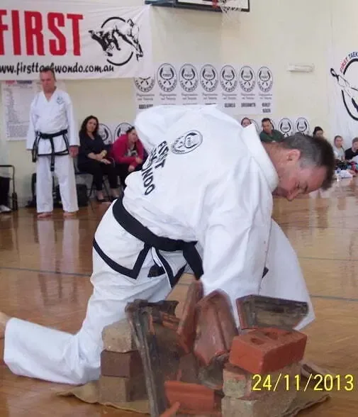 Instructor Carl Fortington punching 4 roof tiles at West Croydon Taekwondo
